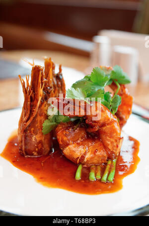 Asian style wok-fried shrimps with sweet-sour sauce on plate Stock Photo