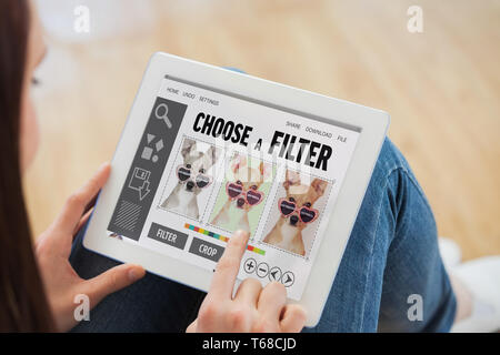 Composite image of teen using a tablet pc sitting on the floor Stock Photo