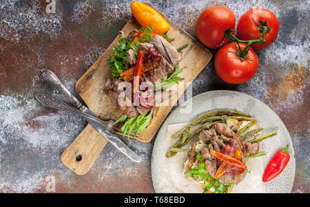 Top view Grilled sandwich with turkey meat, fried asparagus, mushrooms, peppers, tomatoes and greens. Stock Photo