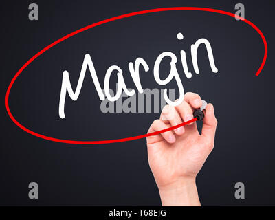 Man Hand writing Margin with black marker on visual screen Stock Photo