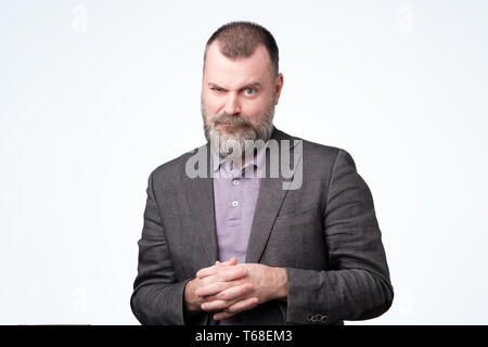 Serious mature european man looking at camera with suspicion. Stock Photo