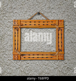 Bamboo frame on gray stucco concrete wall. Stock Photo