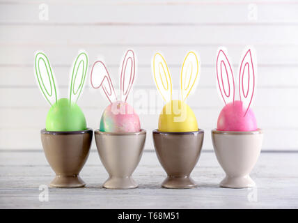 Cute bunny Easter eggs on light table Stock Photo