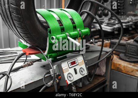A close-up of a car wheel, a tire is standing on a balancing machine for balancing in an automobile workshop. Work at the tire shop. Stock Photo