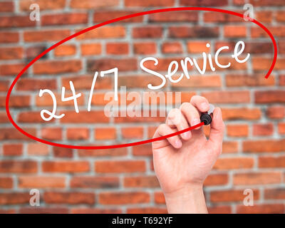 Man Hand writing 24/7 Service with black marker on visual screen Stock Photo