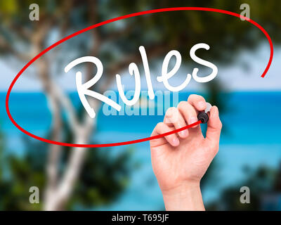 Man Hand writing Rules with black marker on visual screen. Stock Photo