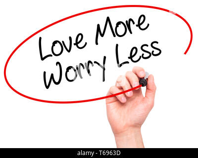 Man Hand writing Love More Worry Less with black marker on visual screen. Stock Photo