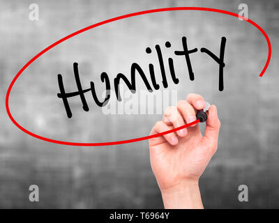 Man Hand writing Humility  with black marker on visual screen. Stock Photo