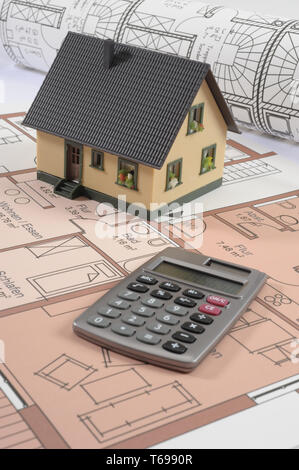 Model house on architectural plan with calculator Stock Photo