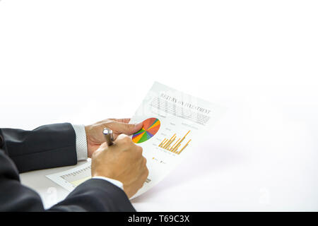 Close-up of businessman hand holding a paper document of financial report of Return on Investment, ROI. Analysing on investment risk management. Isola Stock Photo