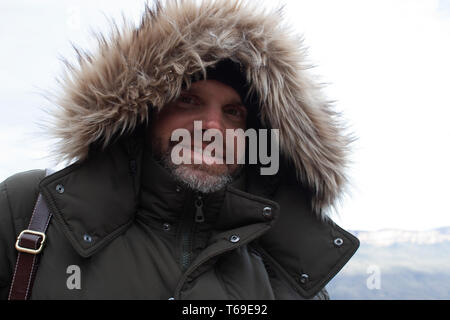 Bearded man in hooded jacket smiling Stock Photo