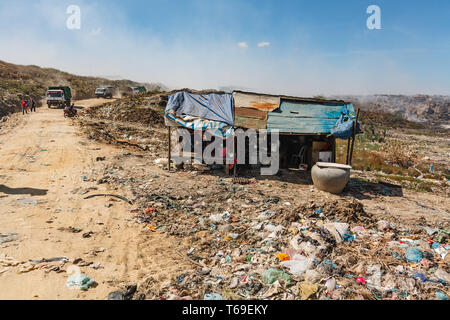 House and road for garbage trucks delivering waste to Stung Meanchey, the  Municipal Waste Dump located in southern Phnom Penh city, Cambodia.  The la Stock Photo