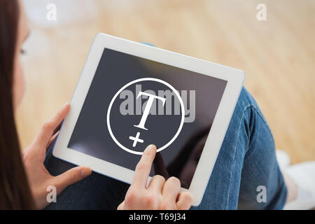 Composite image of teen using a tablet pc sitting on the floor Stock Photo