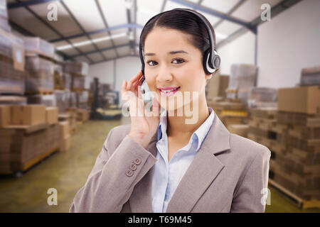 Composite image of portrait of a good looking operator posing with a headset Stock Photo