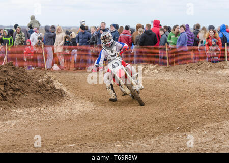 Volgograd, Russia - April 19, 2015: Motorcycle racer rides on the turn track, the spectators in the background, at the stage of Stock Photo