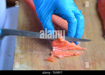 Norwegian chef slicing, filleting or cutting fresh salmon. Norway Stock Photo