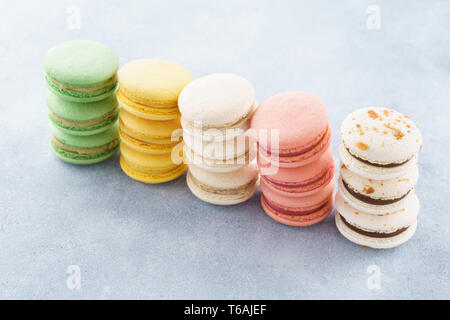 Stacks of colorful macarons with various fillings in a row. Stock Photo