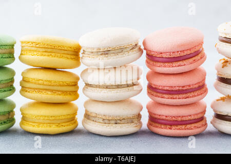 Stacks of colorful macarons with various fillings in a row. Stock Photo