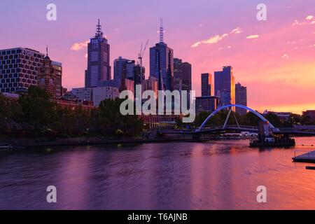 Melbourne city skyline and Flinders Street Station across Yarra River at sunrise, as seen from Southbank Stock Photo