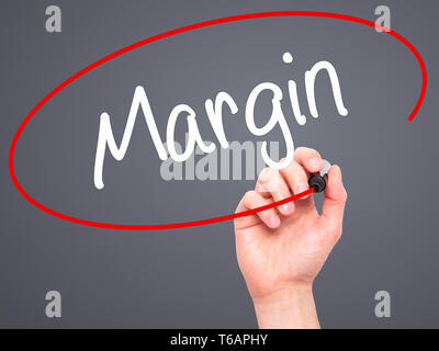 Man Hand writing Margin with black marker on visual screen Stock Photo