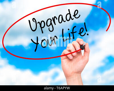 Man Hand writing Upgrade Your Life!  with black marker on visual screen Stock Photo