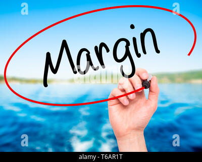 Man Hand writing Margin with black marker on visual screen Stock Photo