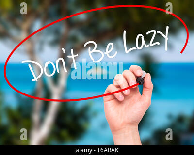 Man Hand writing Don't Be Lazy with black marker on visual screen. Stock Photo