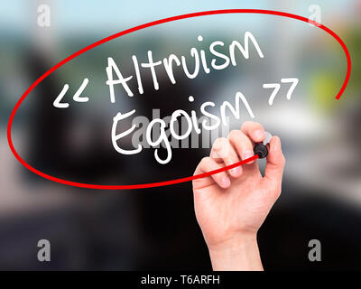 Man Hand writing Altruism - Egoism with black marker on visual screen. Stock Photo