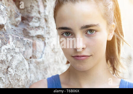 portrait of a beautiful teenager girl leaning against a wall Stock Photo