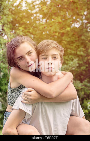 boy carrying his sister on the back Stock Photo