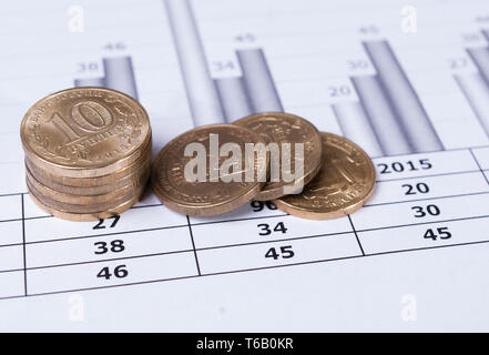Stacks of coins on financial charts. Stock Photo