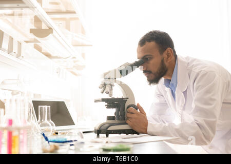 Arabian scientist using modern microscope Stock Photo