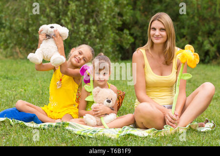 Mother and daughter sitting with soft toys on a picnic Stock Photo