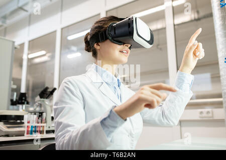 Laboratory worker watching video on VR device Stock Photo