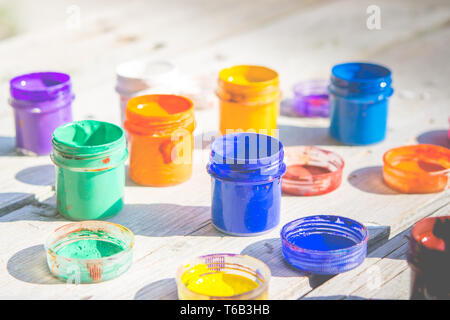 small gouache paint cans stand on a wooden table Stock Photo