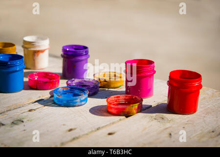 small gouache paint cans stand on a wooden table Stock Photo