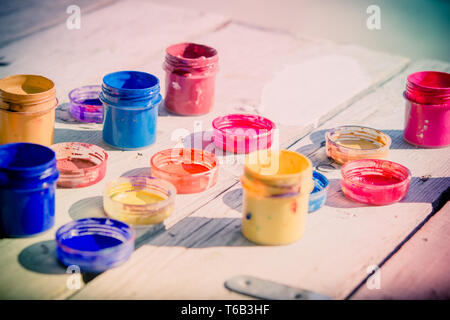 small gouache paint cans stand on a wooden table Stock Photo