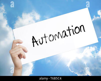 Automation Sign on white paper. Man Hand Holding Paper with text. Isolated on sky background Stock Photo