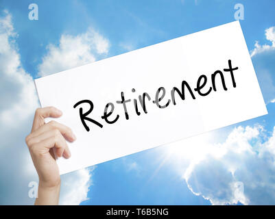 Retirement Sign on white paper. Man Hand Holding Paper with text. Isolated on sky background Stock Photo