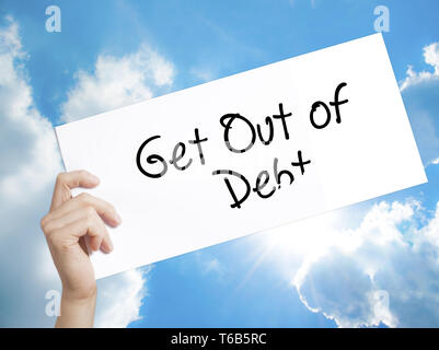 Get Out of Debt Sign on white paper. Man Hand Holding Paper with text. Isolated on sky background Stock Photo
