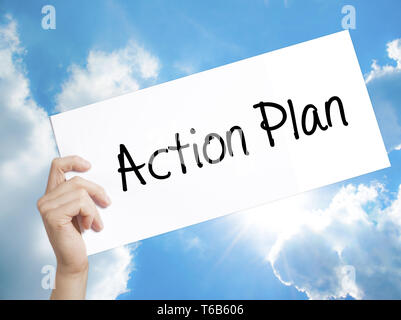 Action Plan Sign on white paper. Man Hand Holding Paper with text. Isolated on sky background Stock Photo