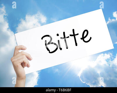 Bitte (Please in German) Sign on white paper. Man Hand Holding Paper with text. Isolated on sky background Stock Photo