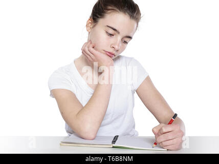 bored teenage girl is doing her homework Stock Photo