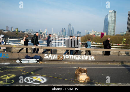 Extinction Rebellion protest, London . Waterloo Bridge. Commuters walk over the bridge closed to traffic by the XR protest. Stock Photo