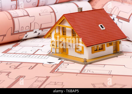 model house standing on architectural construction plans Stock Photo