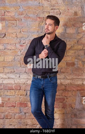 Portrait of a thinking handsome young businessman in a black shirt. Stock Photo