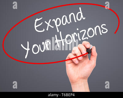 Man Hand writing  Expand Your Horizons  with black marker on visual screen Stock Photo