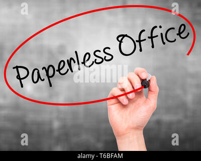 Man Hand writing Paperless Office  with black marker on visual screen Stock Photo
