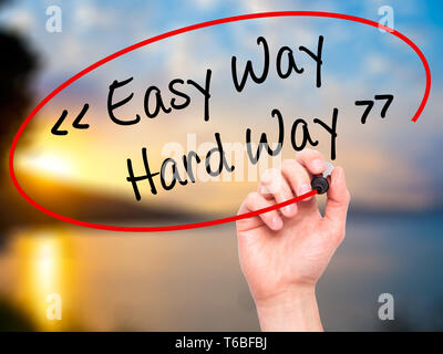 Man Hand writing Easy Way - Hard Way with black marker on visual screen. Stock Photo