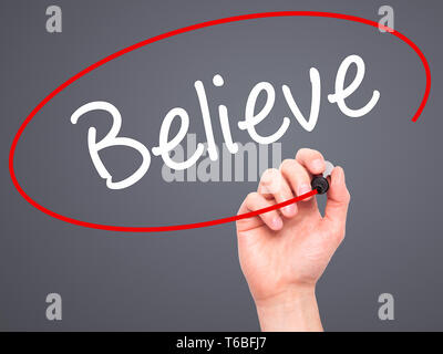 Man Hand writing Believe with black marker on visual screen Stock Photo